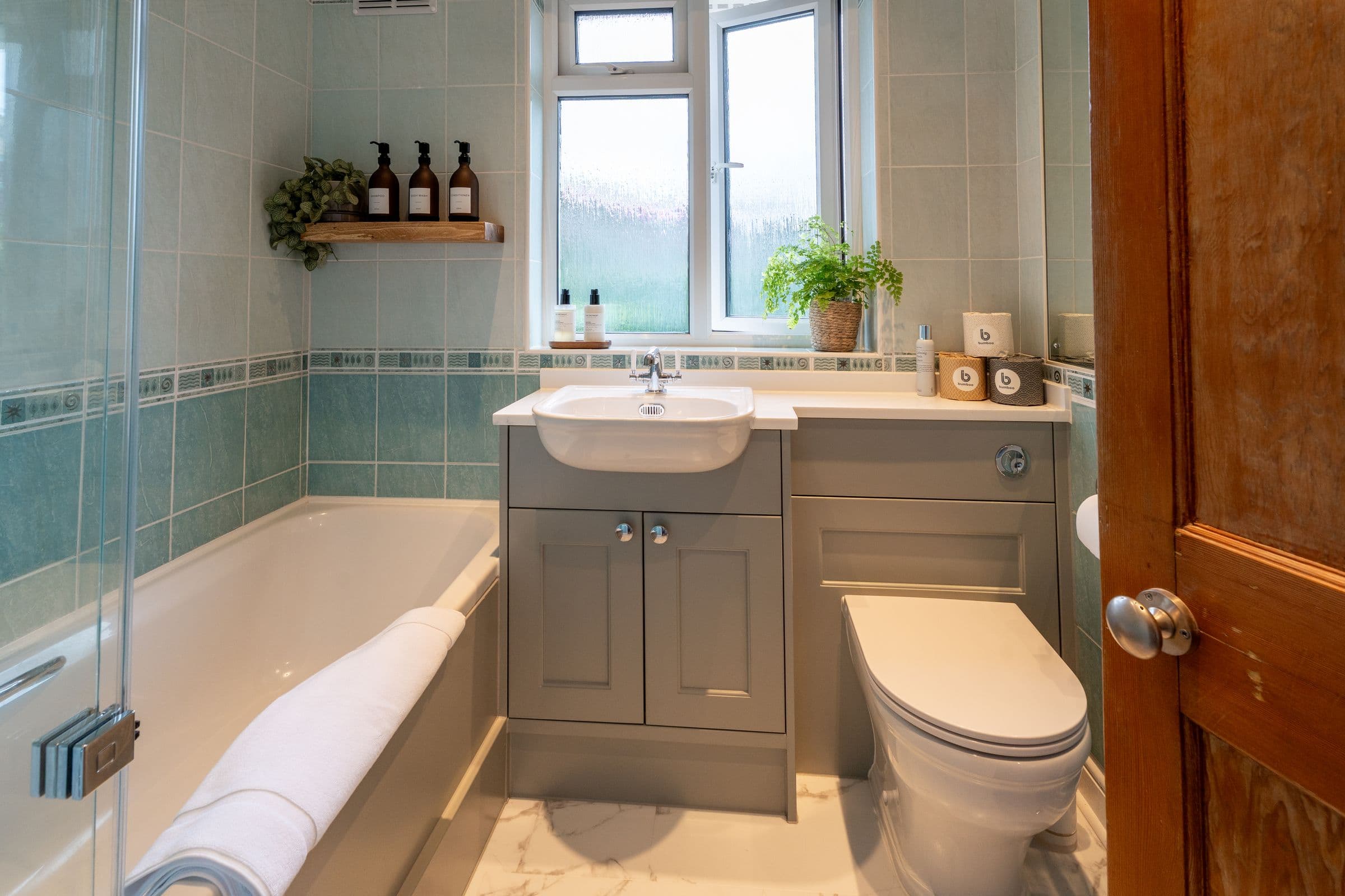 The bath with its shower screen, basin unit and towel rail.