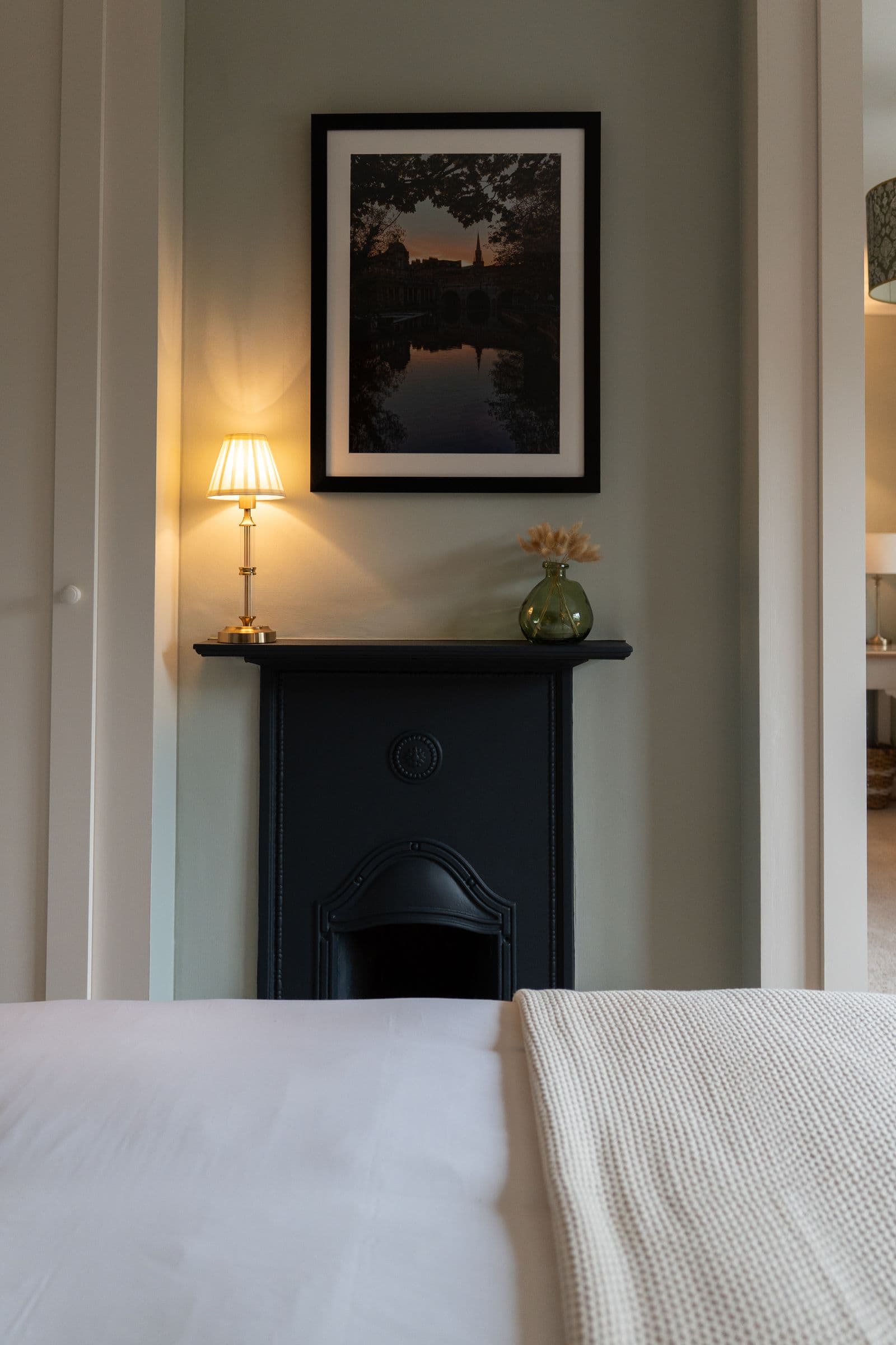The main bedroom's original fireplace, with the lamp lit beside it.