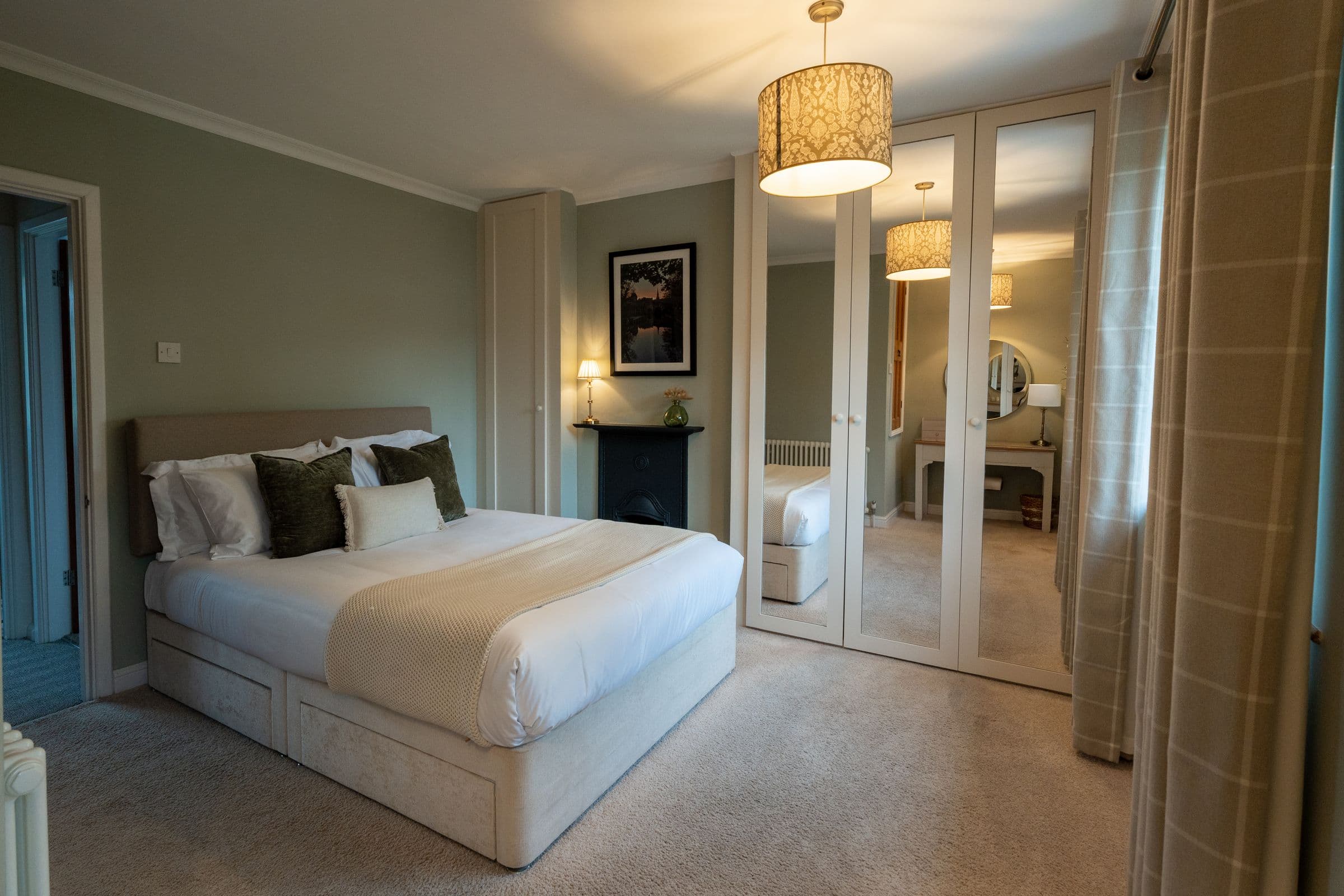 The main bedroom's bed and mirrored wardrobes, with the pendant lit.
