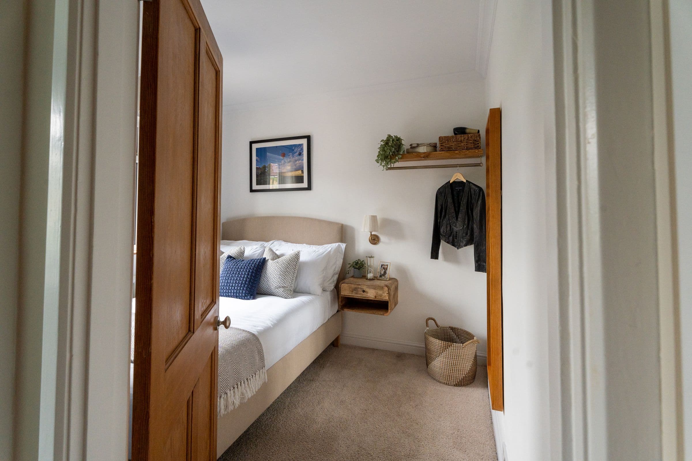The second bedroom seen through the doorway, with the full-length mirror.