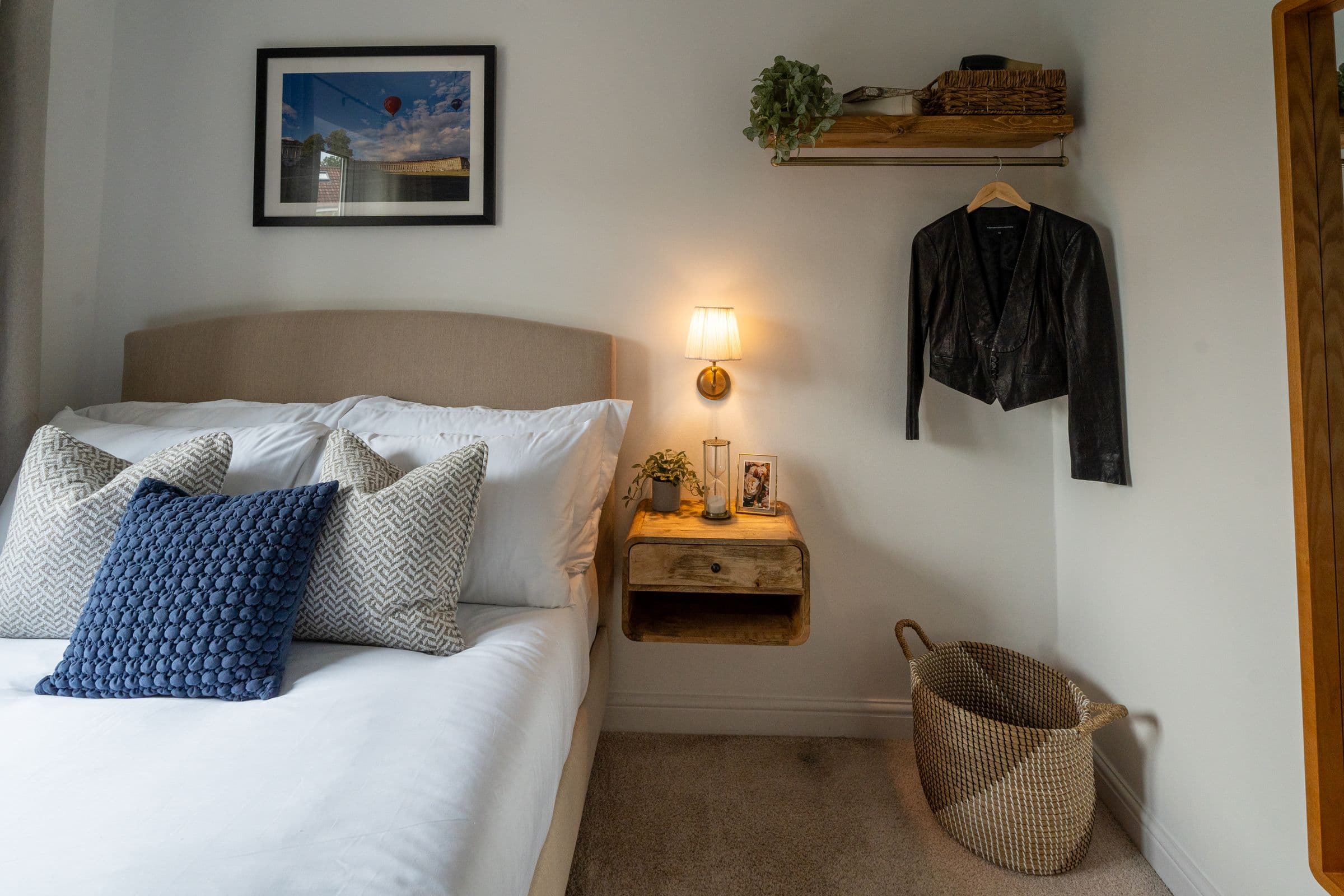 The second bedroom's bed and its floating bedside shelf, with the wall light on.