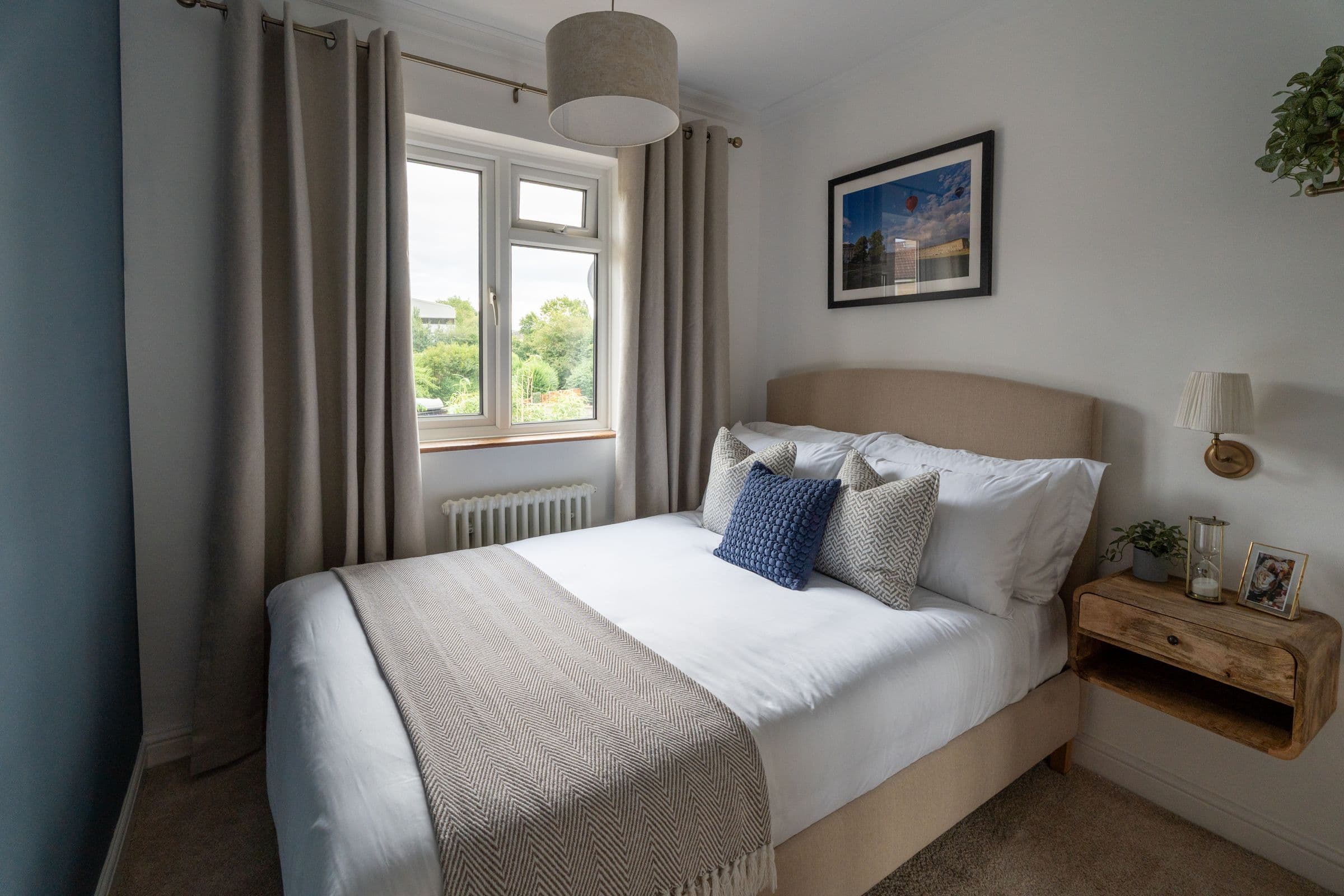The second bedroom looking towards the window, with the pendant light above.