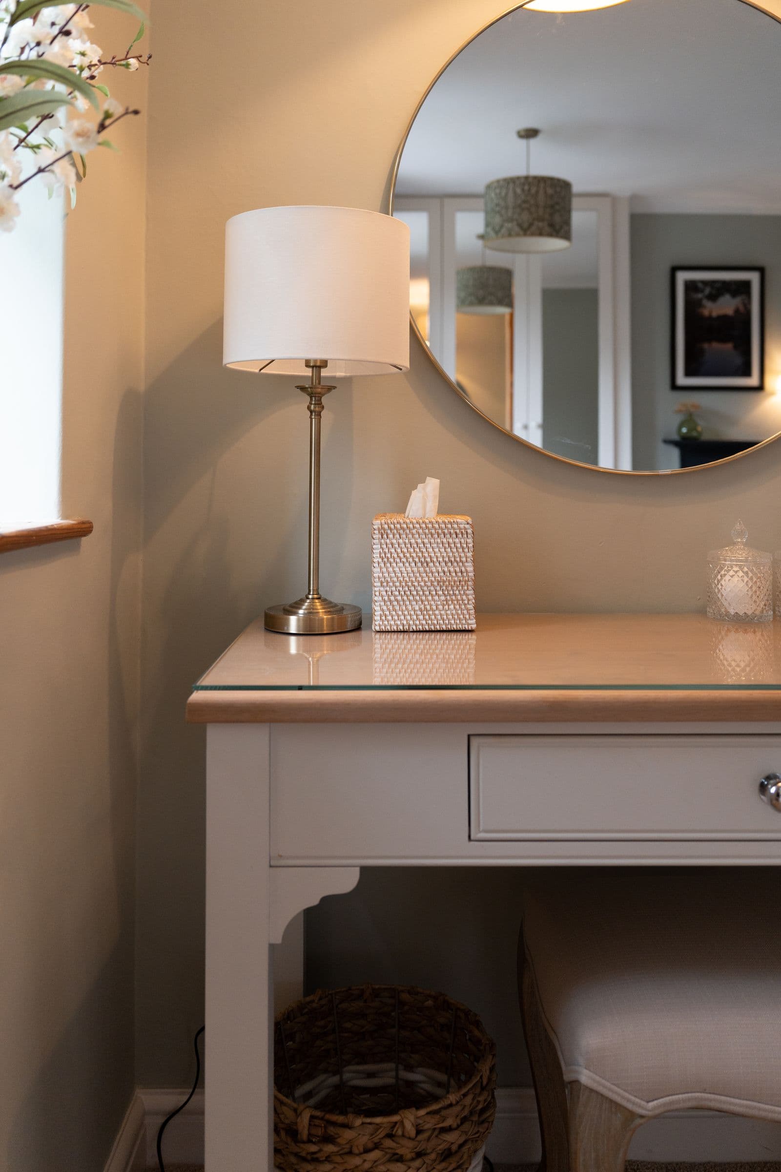 The dressing table with its lamp and round mirror.