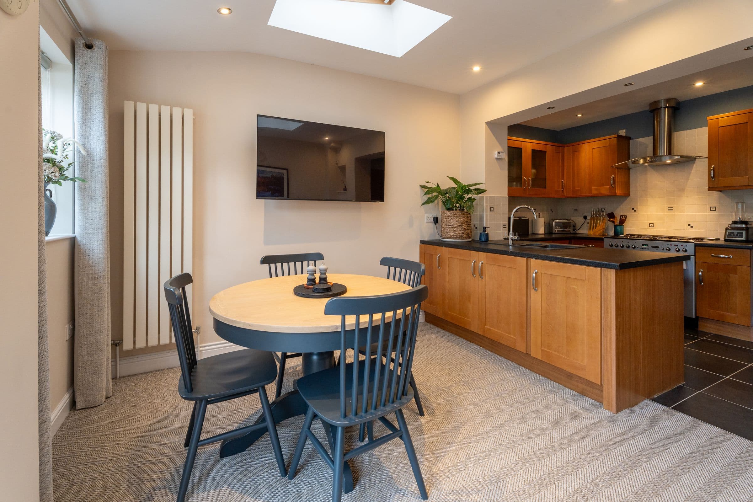 The dining table beneath the skylight, with the kitchen beyond.