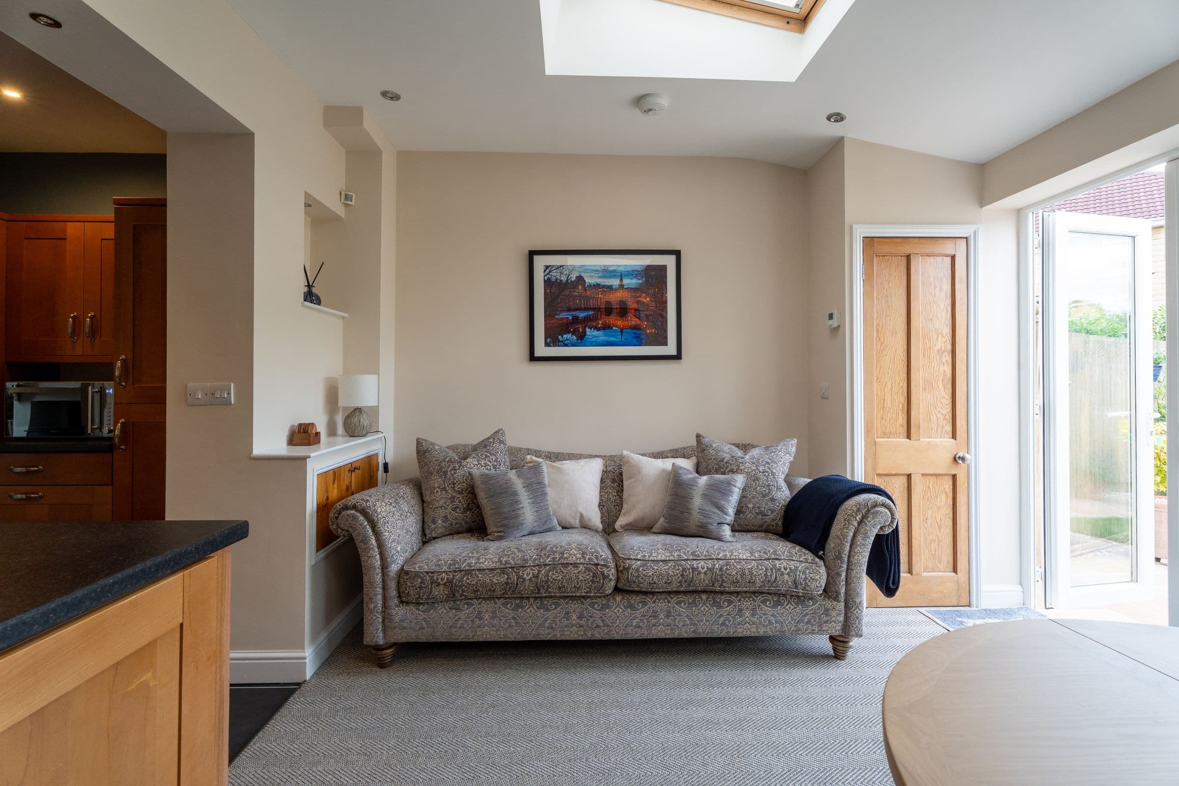 The sofa in the garden room, with the window light across the cushions.