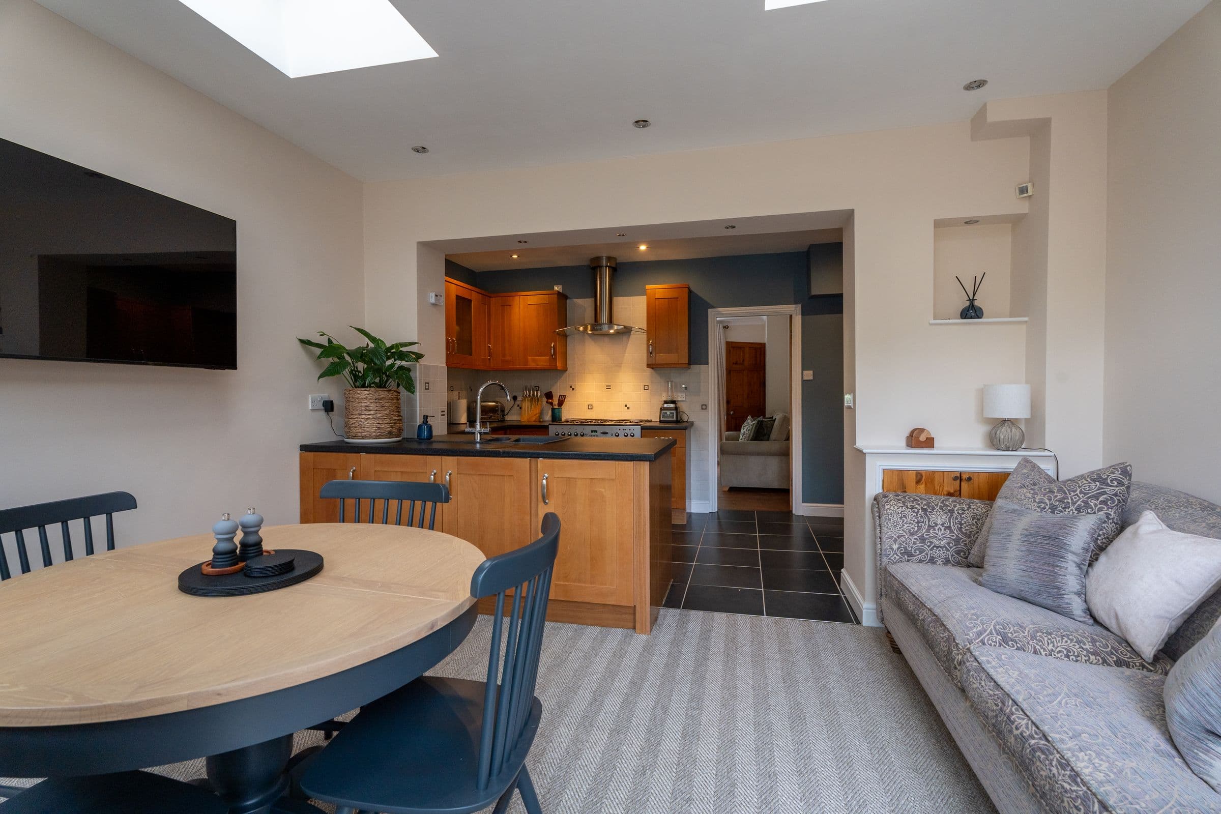 The round dining table, with the kitchen beyond and the sofa alongside.
