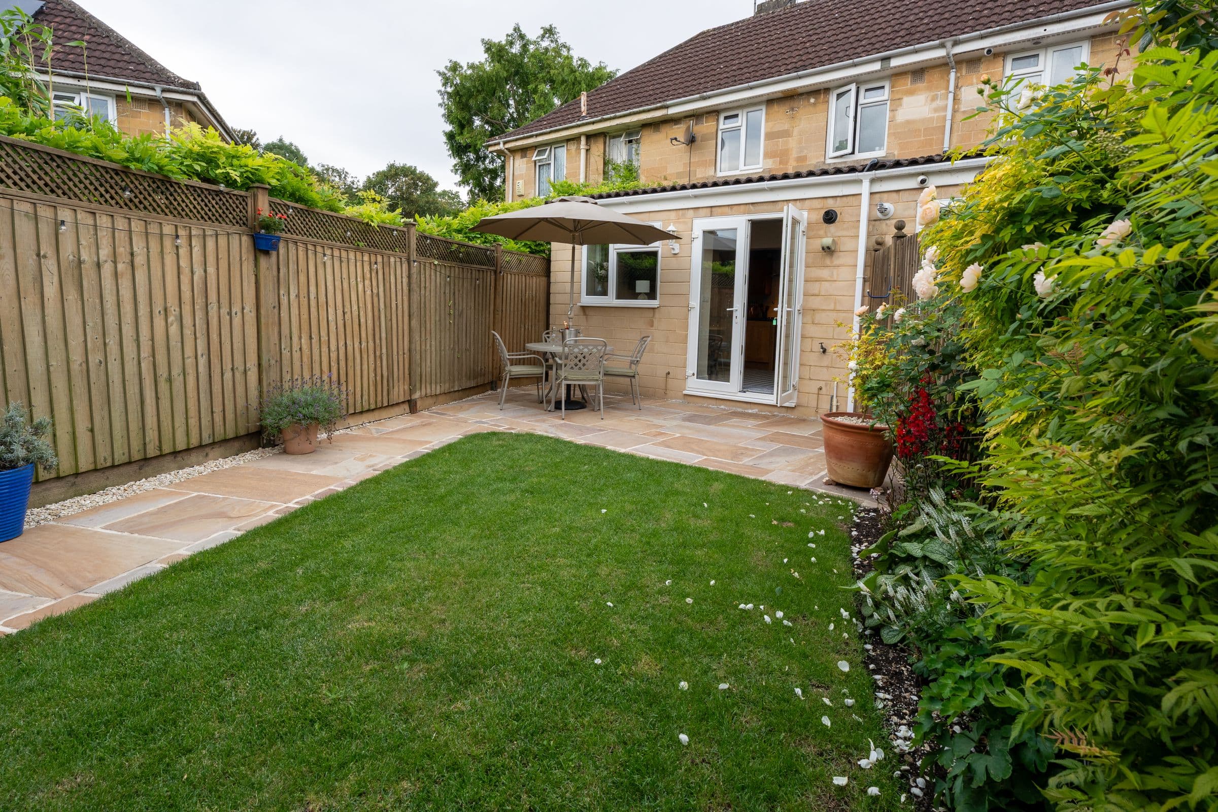 The garden's planted borders and lawn, looking along the fence.