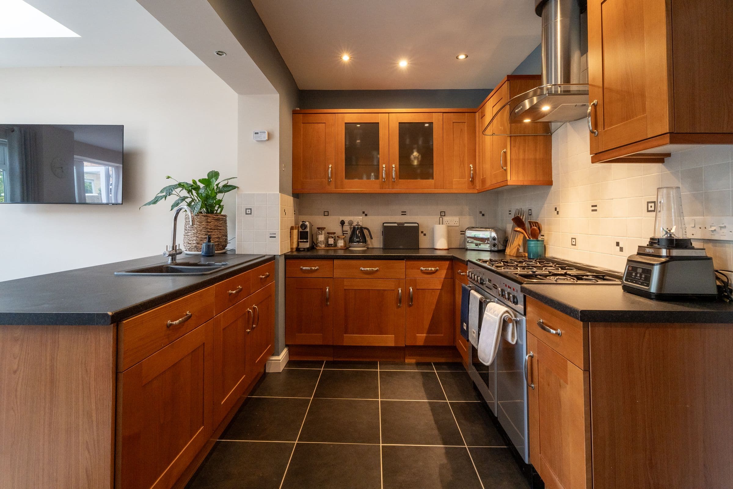 The kitchen from the far end, with the television on the wall.