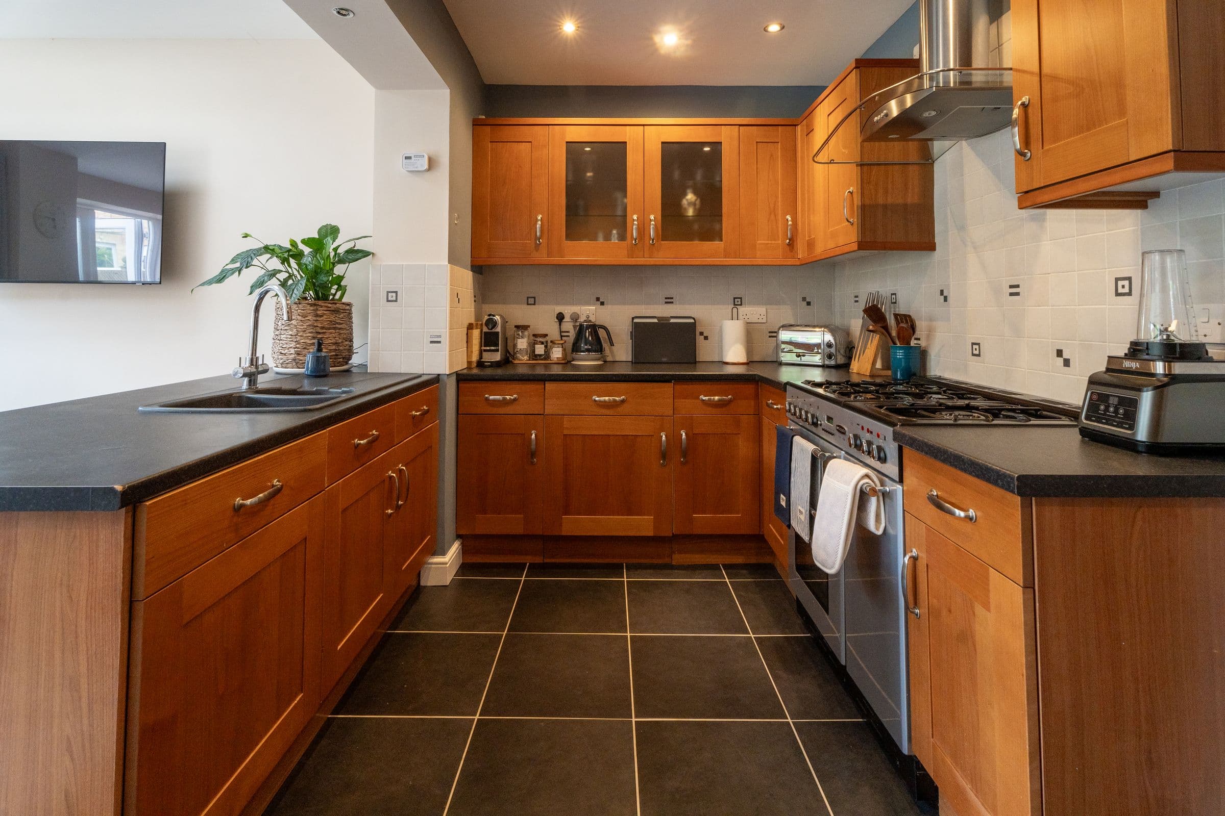 The kitchen, with its run of oak units, tiled floor and range cooker.