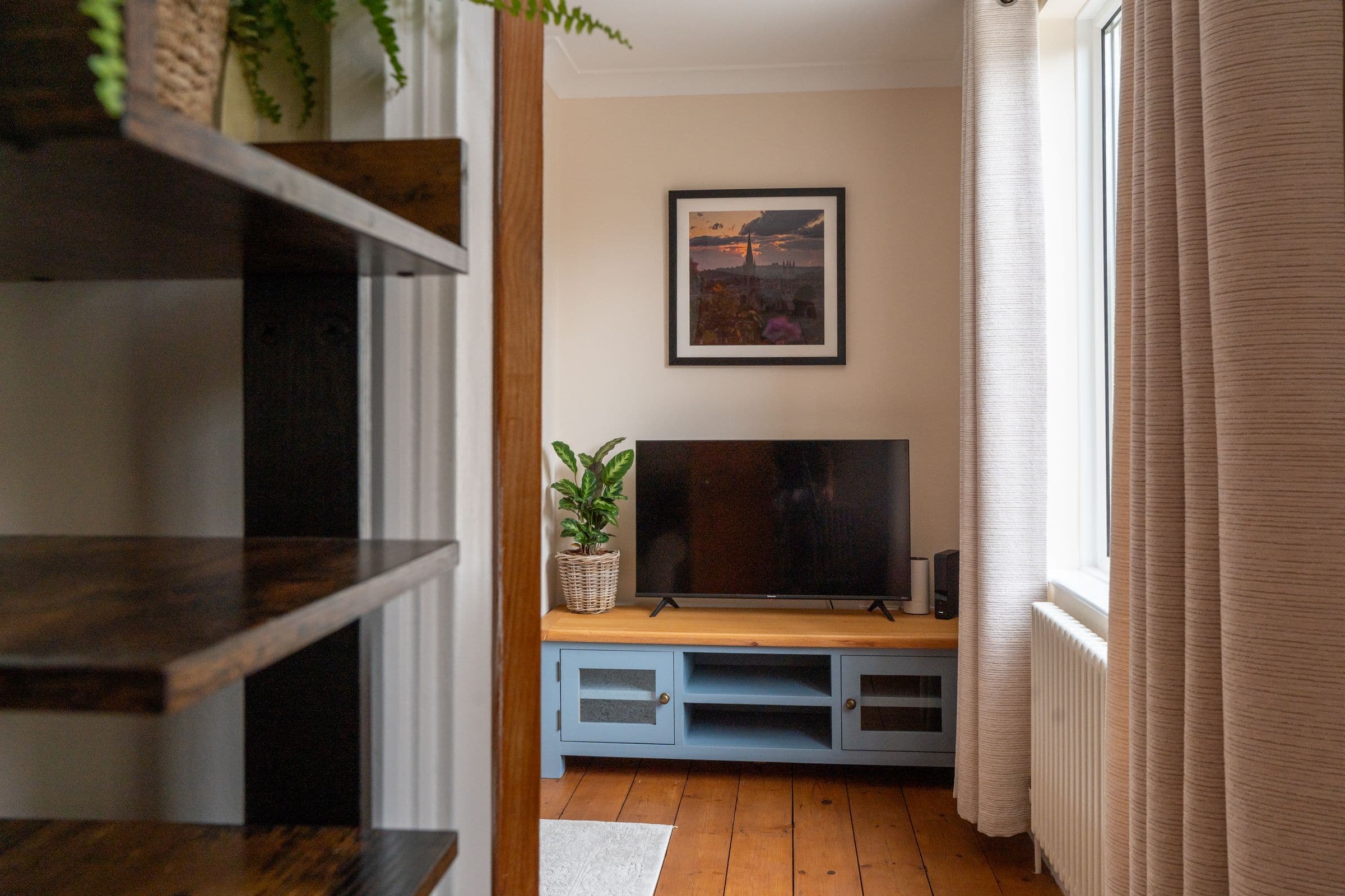 The living room shelves and television, looking towards the window.