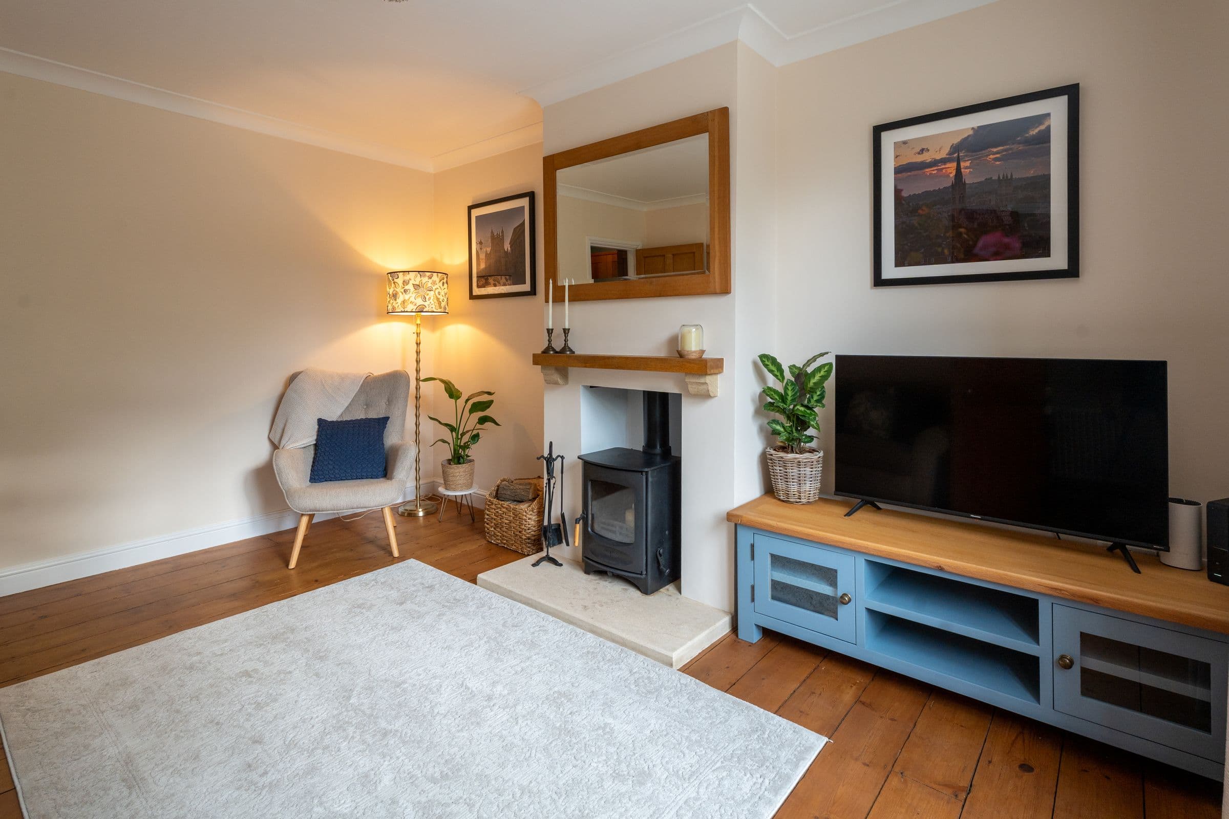 The living room in the evening, with the floor lamp lit beside the armchair.